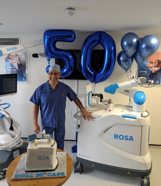 consultant in scrubs smiling with 50 balloons