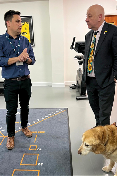 two men talking with guide dog