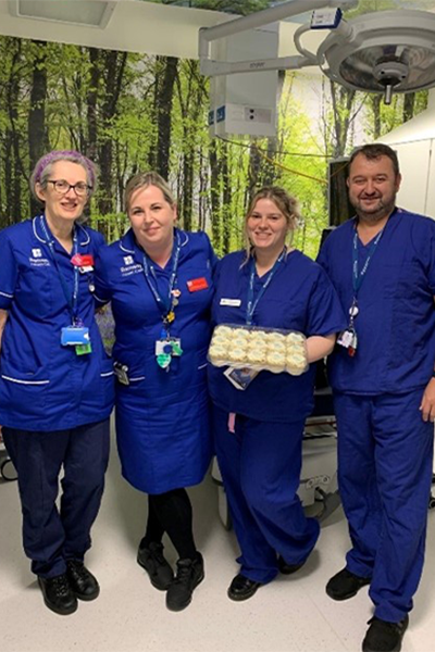 group of smiling hospital workers with cupcakes