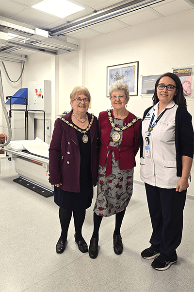 three women smiling by hospital bed
