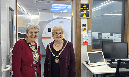 two women smiling by mri scanner