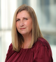 Lisa Jefferies, Chief People Officer smiling in a red top