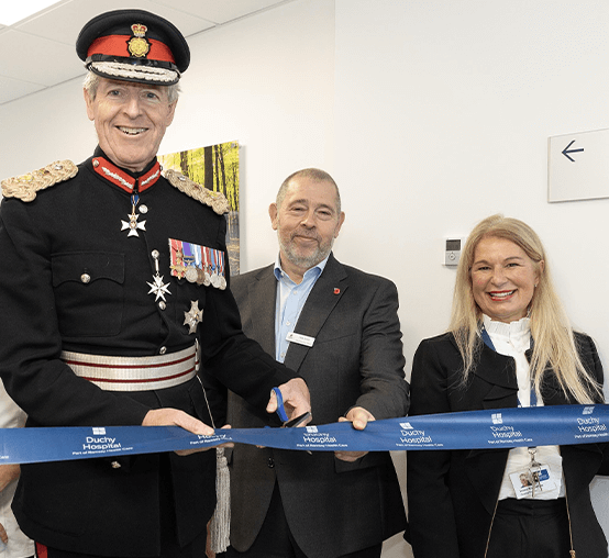 three people smiling cutting ribbon