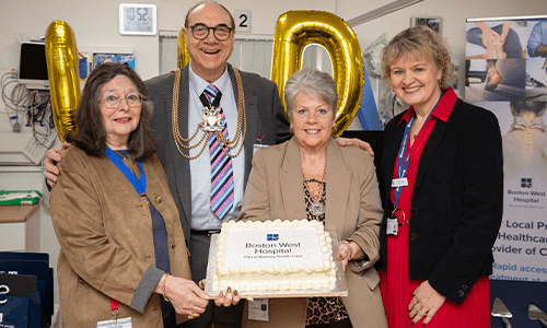 four people smiling with a cake