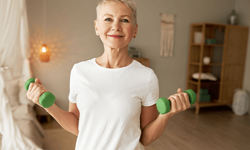 woman smiling holding dumbells