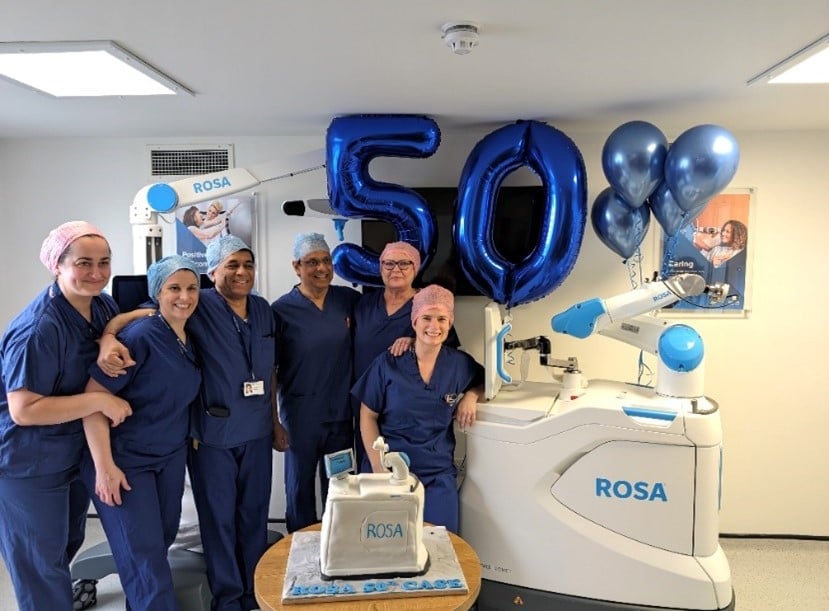 group of medical staff smiling with 50 balloons